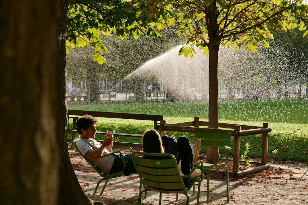 Two Brazilian friends having a calm conversation on a park bench